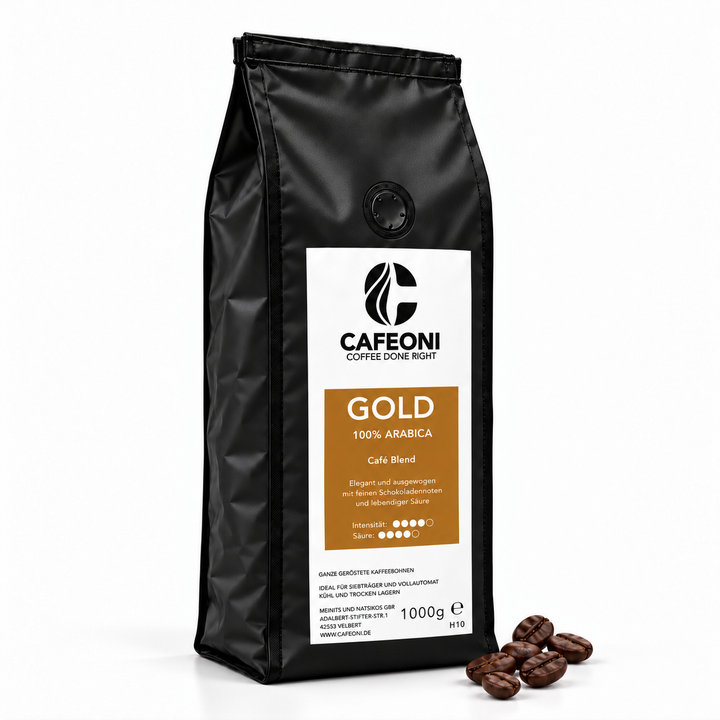 CAFEONI GOLD Kaffeebohnen 1 kg – mittig platzierte schwarze Verpackung mit Kaffeebohnen rechts daneben
